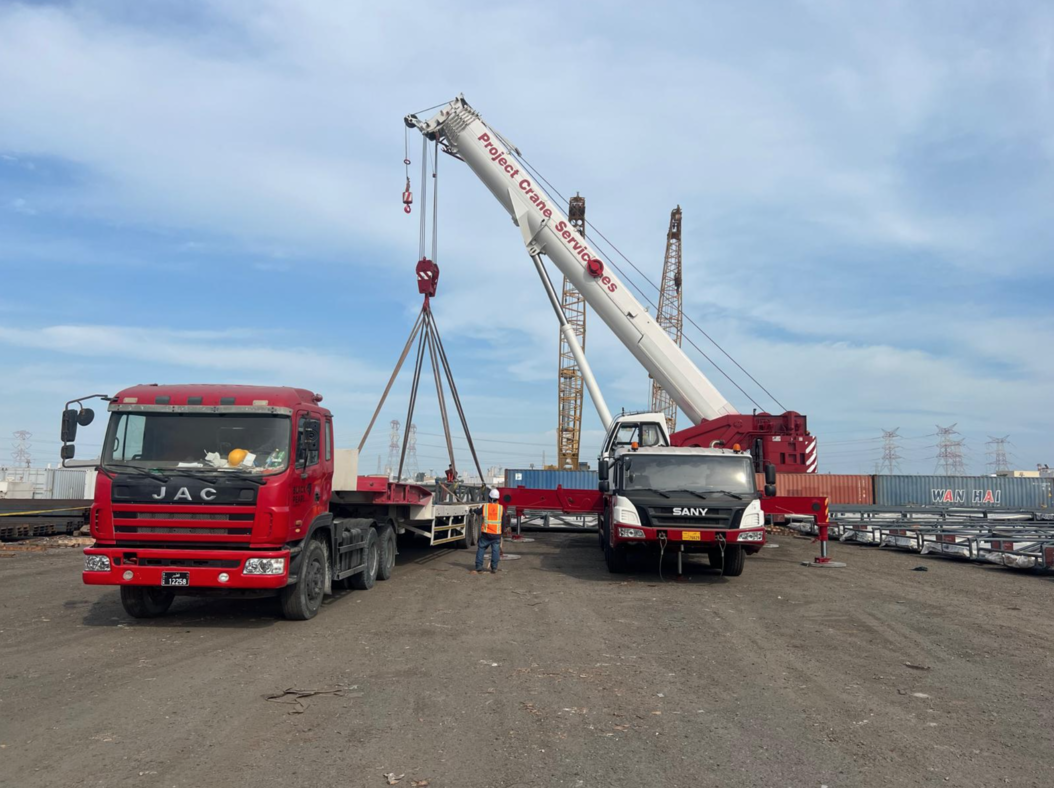 Crane lifting operation with trucks